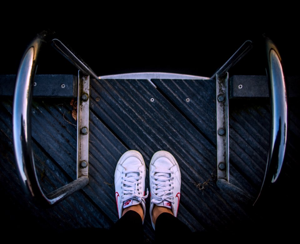 person wears pair of white low-top sneakers