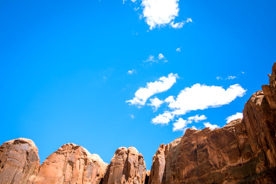 brown cliff under white and blue cloudy sky