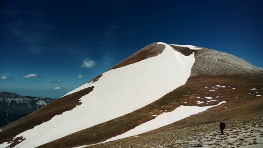 person standing on sand and hill at distance