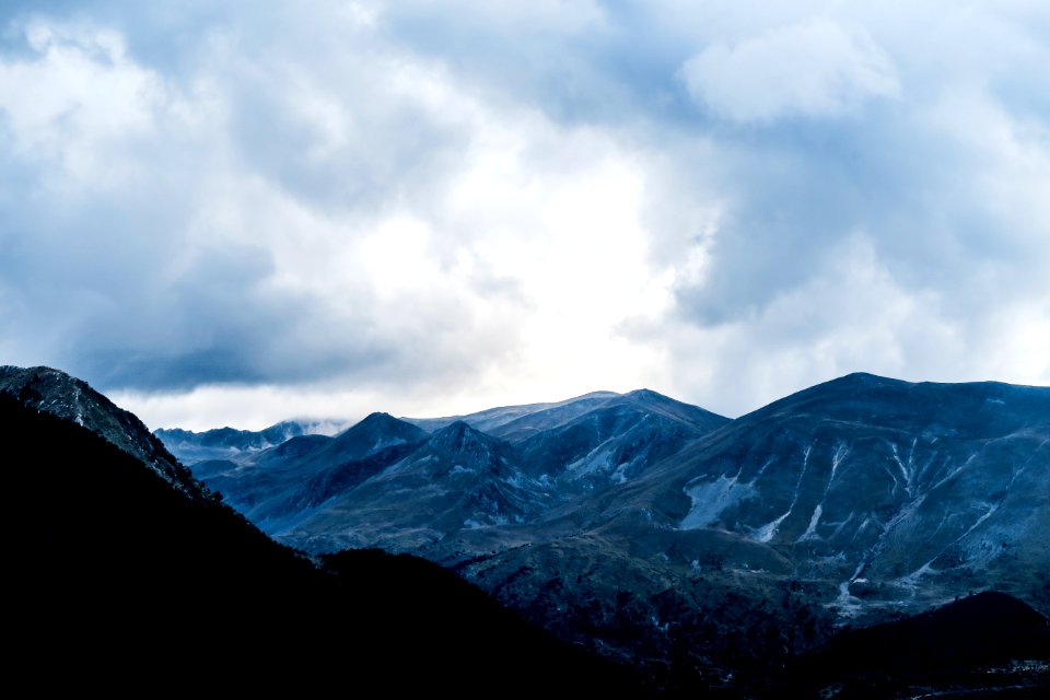 mountain range under cloudy sky during daytime