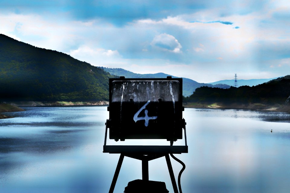 A sign marked with the number four over a lake
