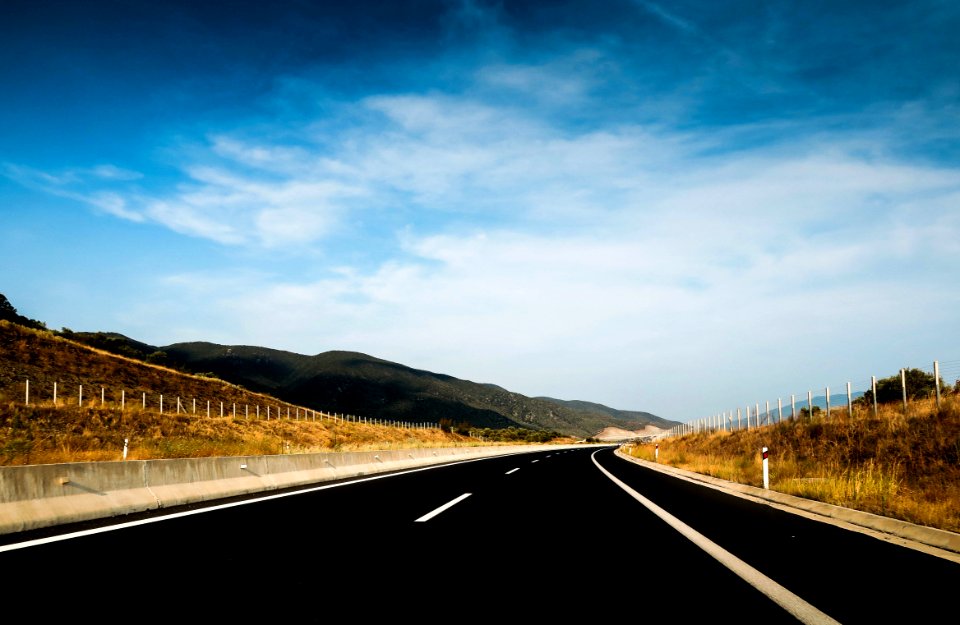 mountain ranges near road under cloudy sky