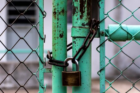 green metal gate with brown metal padlock photo