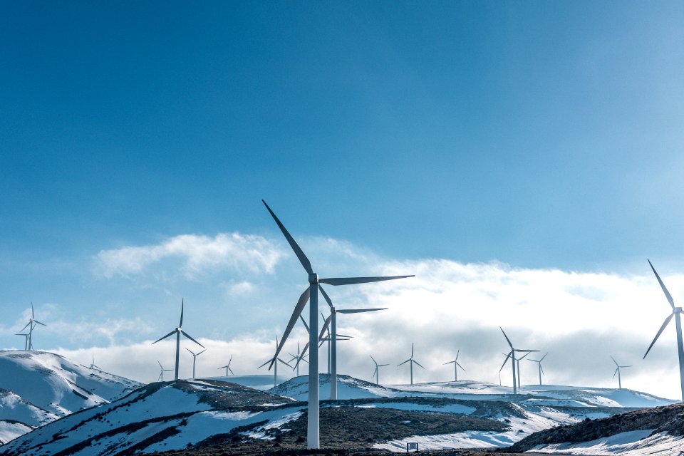 wind turbines on snowy mountain under clear blue sky during daytime