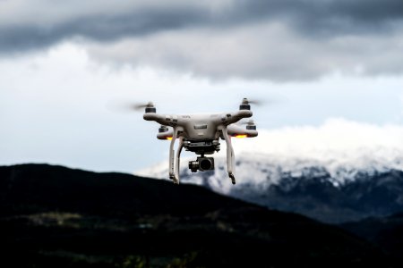 flying white quadcopter drone at daytime