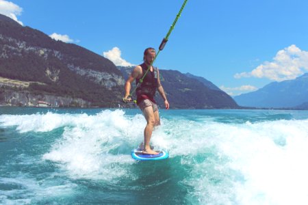 man wakeboarding on blue sea under blue and white skies photo