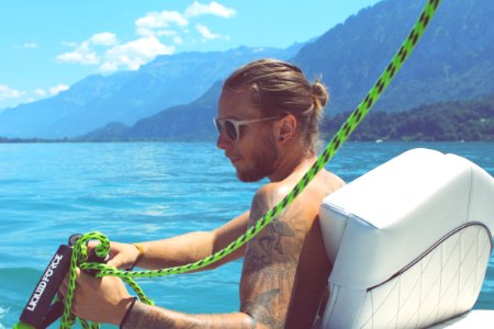man holding black and green rope near body of water during daytime photo