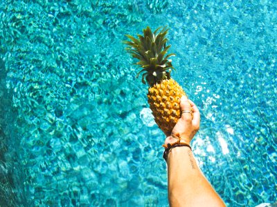 person holding yellow pineapple photo