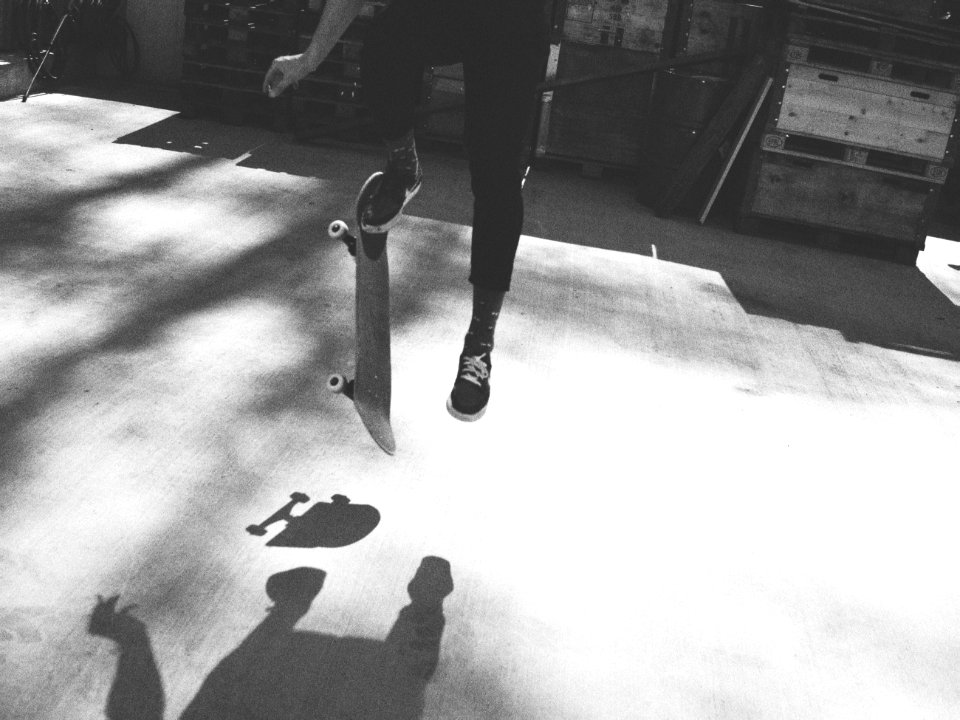 grayscale photography of person doing skateboard tricks