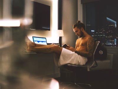 man sitting on rolling chair while using smartphone photo