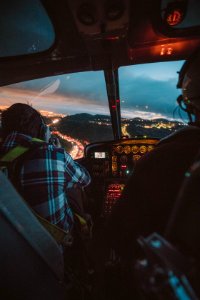 photography of man riding helicopter during nighttime photo