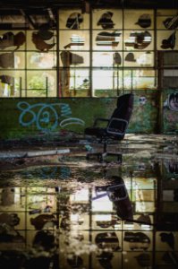 photo of black rolling armchair in an abandoned building photo