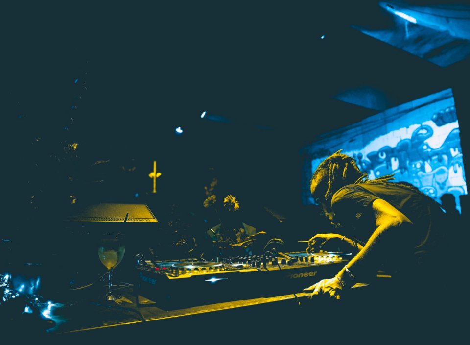 man playing audio mixer in club