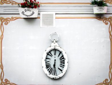 oval white analog clock display at 6 o'clock photo