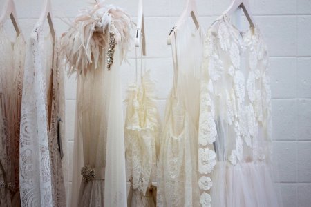 six women's white dresses hanging on hangers photo