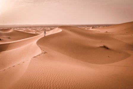 person walking on desert photo