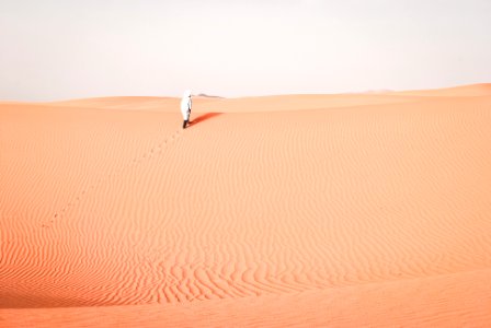 person walking on desert during daytime photo