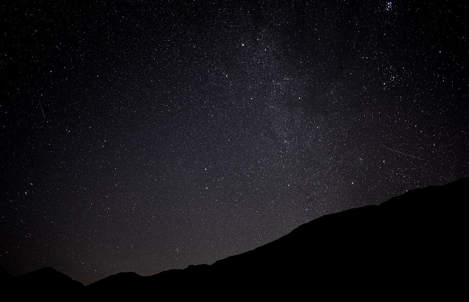 silhouette photo of mountain under star trail