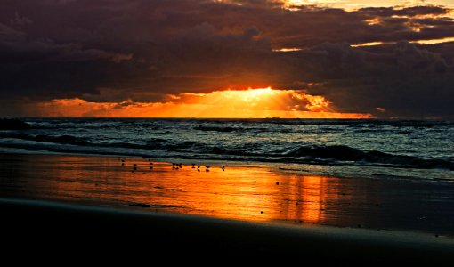 sea waves crashing on shore during sunset photo