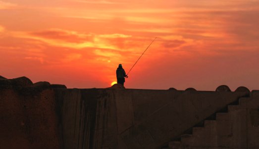 silhouette of person standing during golden hour photo