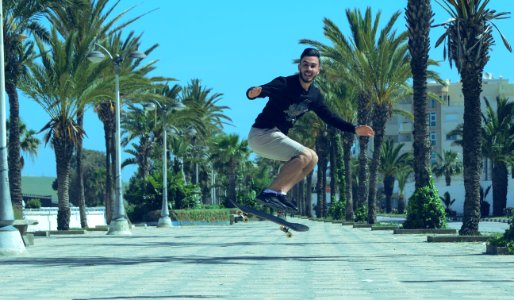 man in black jacket and black pants riding skateboard during daytime photo