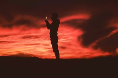 silhouette of man holding lighter photo