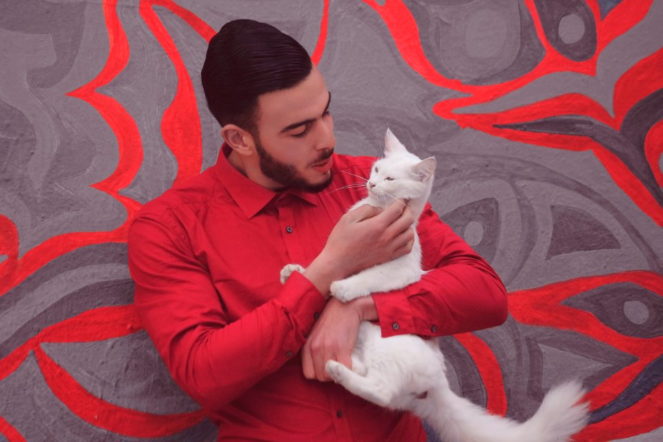 man in red dress shirt holding white cat