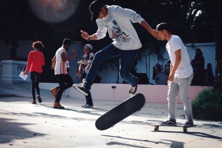 man in white t-shirt and black pants holding skateboard photo