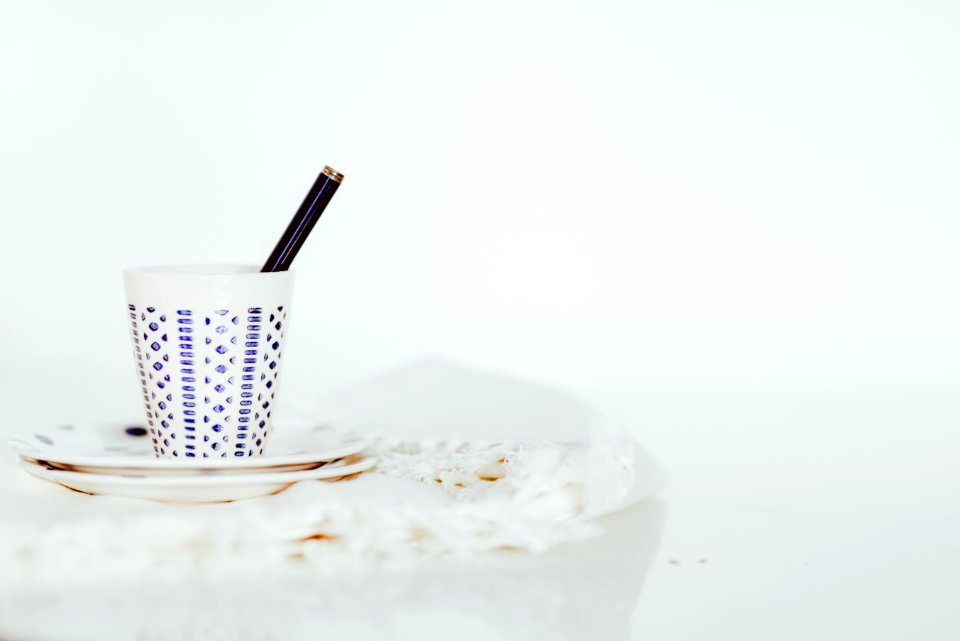 white cup with pen on white panel