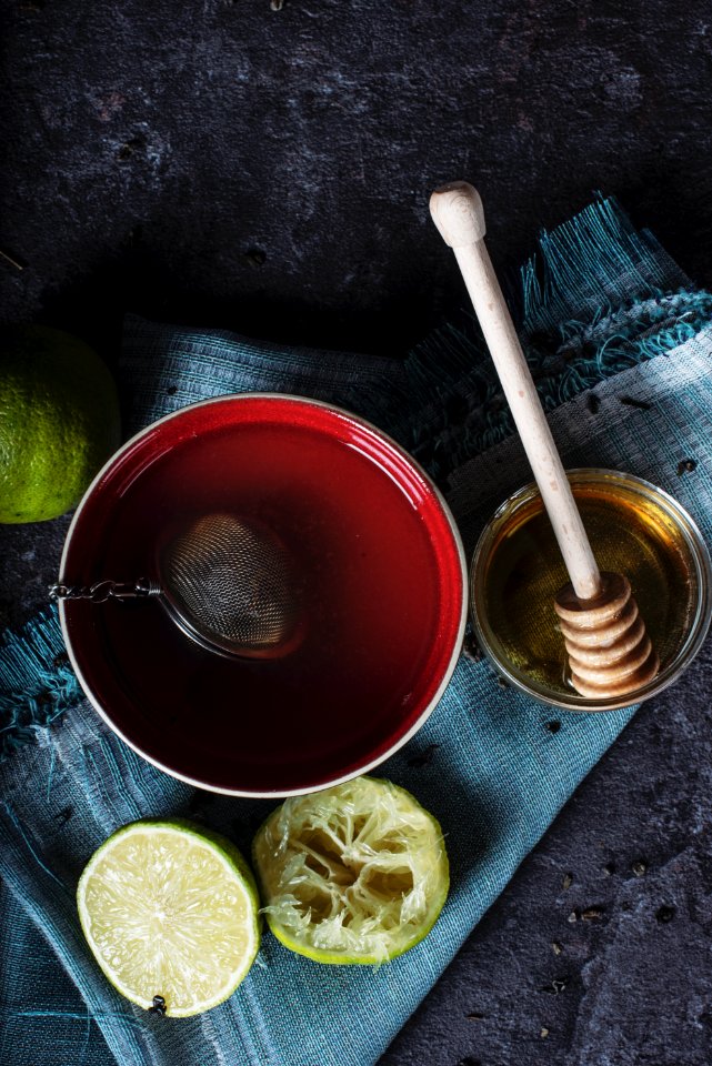 red ceramic bowl filled with water beside lime and honey photo