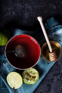 red ceramic bowl filled with water beside lime and honey photo