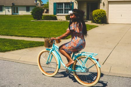 woman in brown and blue dress riding blue bicycle photo