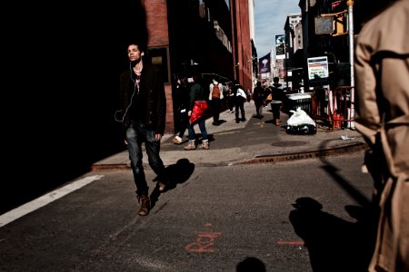 man walking on road using earbuds
