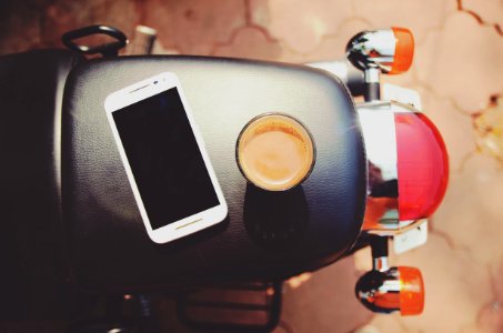 white smartphone on black leather motorcycle seat photo