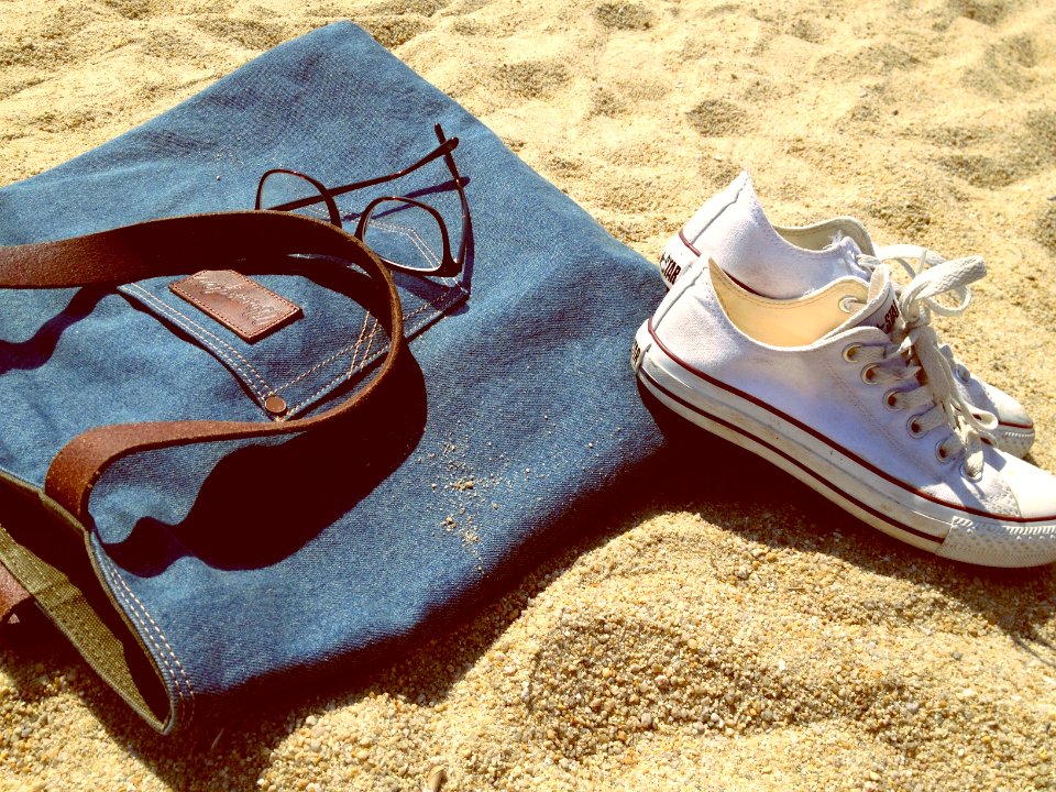 pair of white low-top sneakers on brown sand
