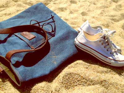 pair of white low-top sneakers on brown sand