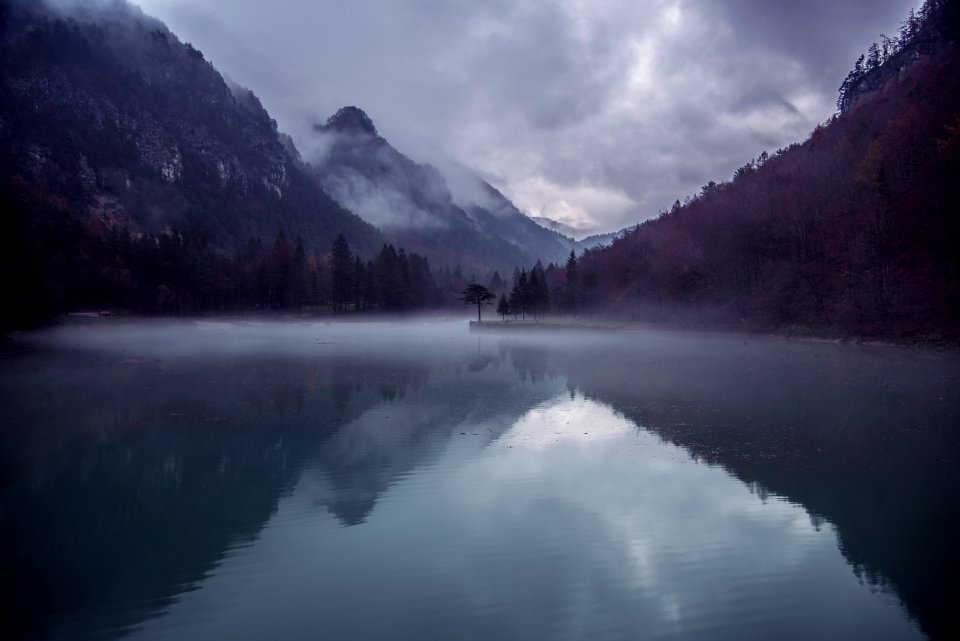 body of water surrounded by mountain during daytime