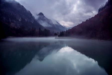 body of water surrounded by mountain during daytime photo