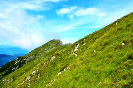 green grassy mountain under blue cloudy sky