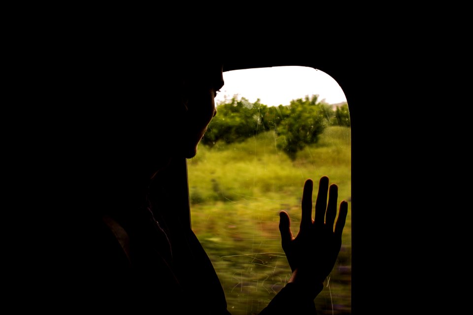 silhouette of person looking on window