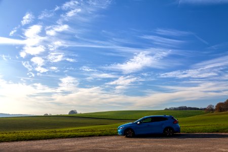 blue 5-door hatchback on asphalt road during daytime