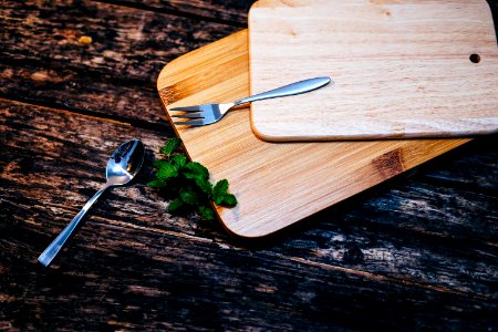 stainless steel spoon and fork on brown wooden board photo