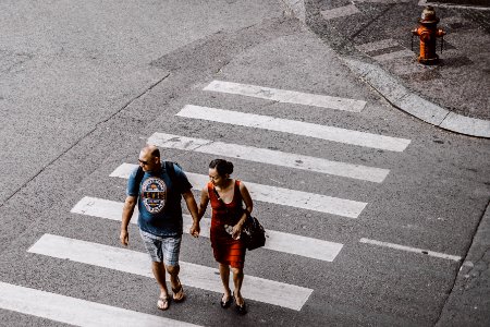 man and woman walking on pedestrian lane during daytime photo