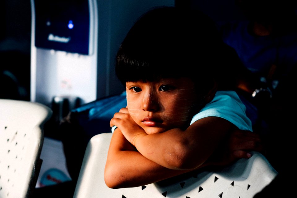 boy leaning on white chair