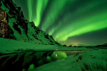 snow covered mountain with aurora borealis photo