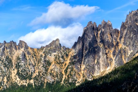 rock mountains under blue and white sky photo