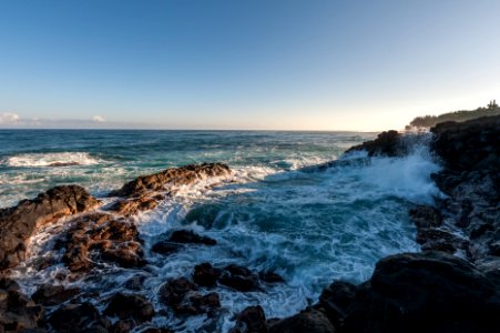 ocean waves hammering rock boulders photo