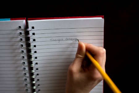 person writing on notebook photo
