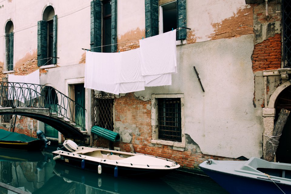 white and blue motorboat near wall during daytime