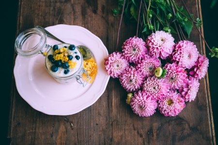 pink dahlia flowers beside ceramic plate with jar photo